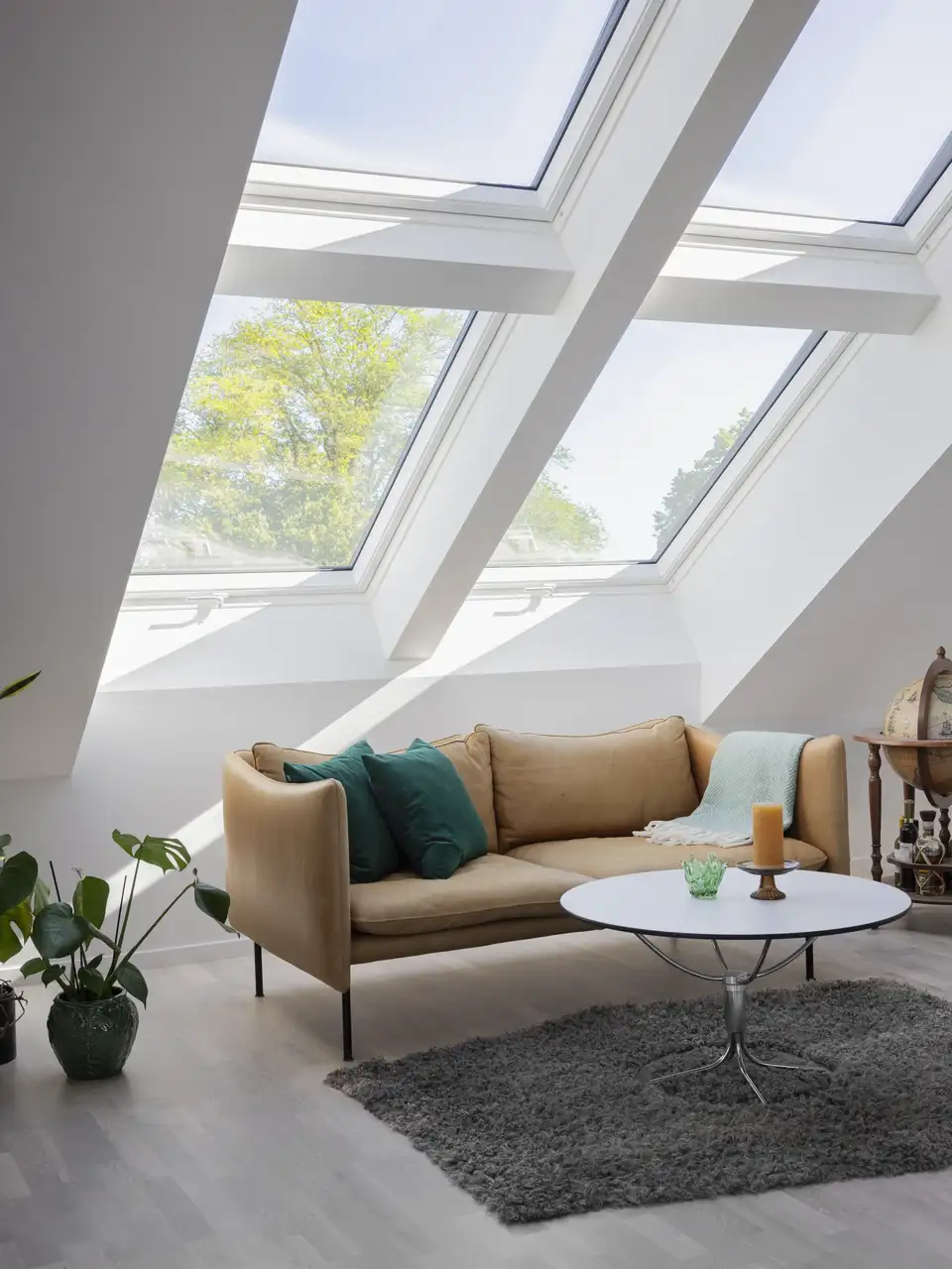 Soggiorno in mansarda con quattro grandi finestre per tetti VELUX, affiancate e sovrapposte