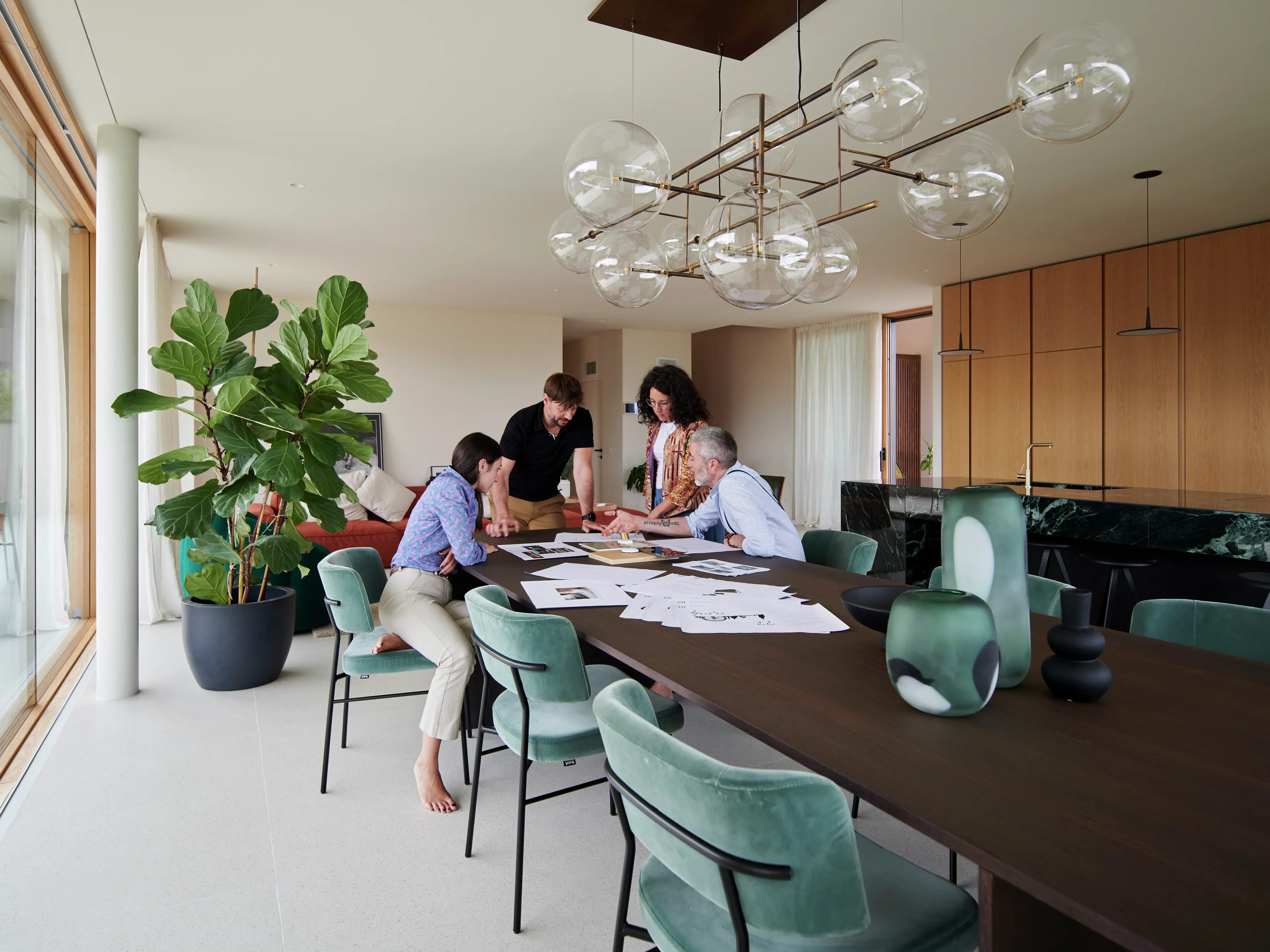 Des professionnels réunis autour d'une table dans un bureau à domicile moderne avec une décoration élégante.