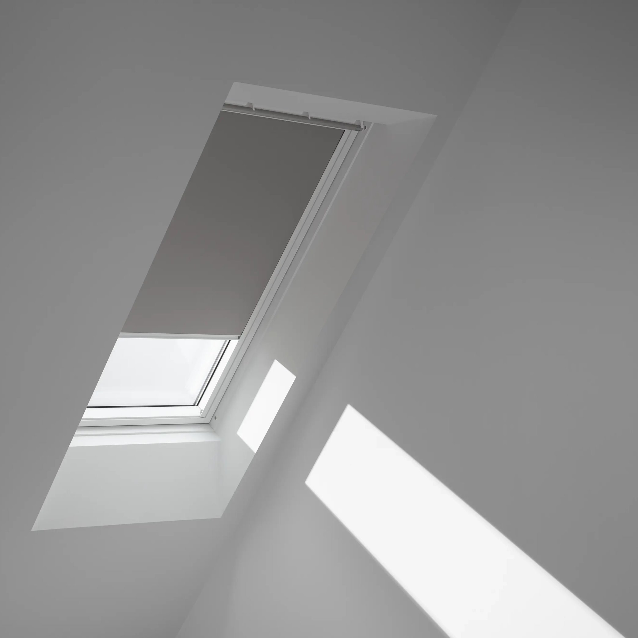 Attic with sloped ceiling and VELUX roof window, natural light streaming in.