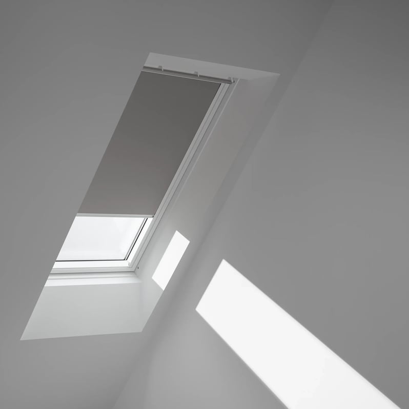 Attic with sloped ceiling and VELUX roof window, natural light streaming in.