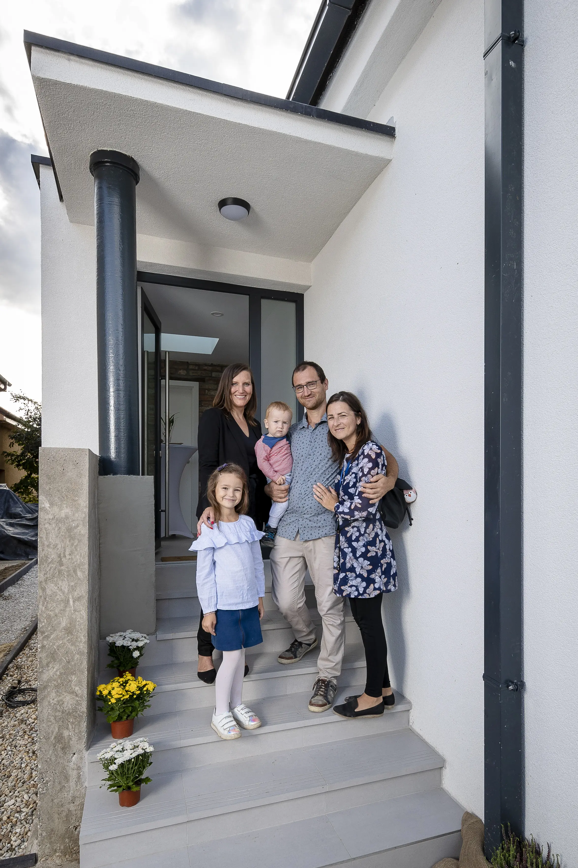 Rodina Hučkovcov na schodisku nového domu zrekonštruovaného s projektom VELUX RenovActive