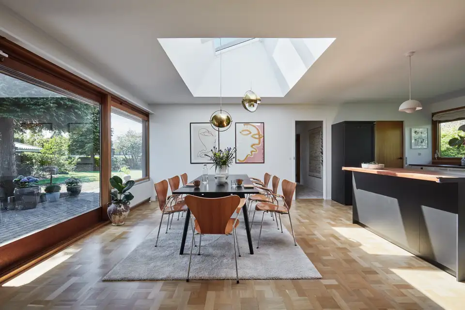 Lambalar ve VELUX çatı pencereleri olan yemek masası.