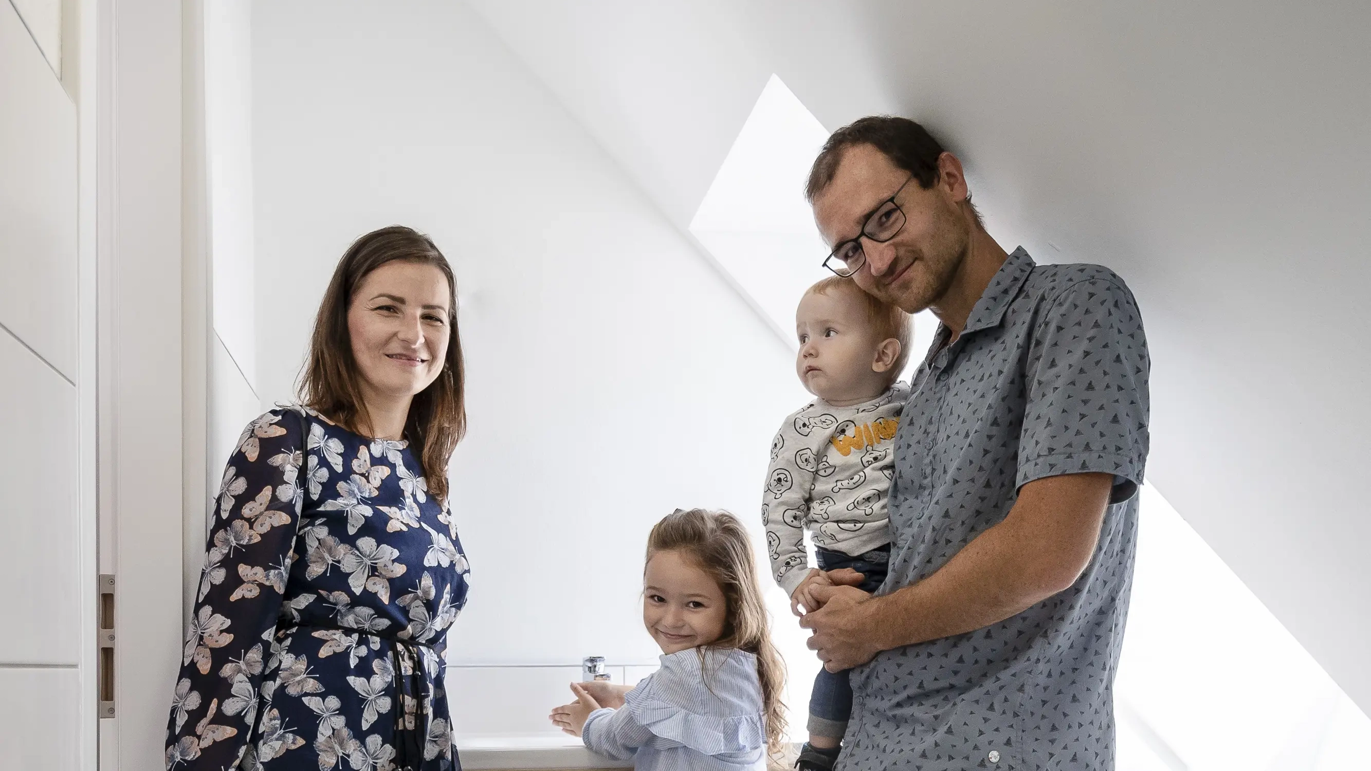 Family in a modern bathroom with sloped ceiling and VELUX roof window.