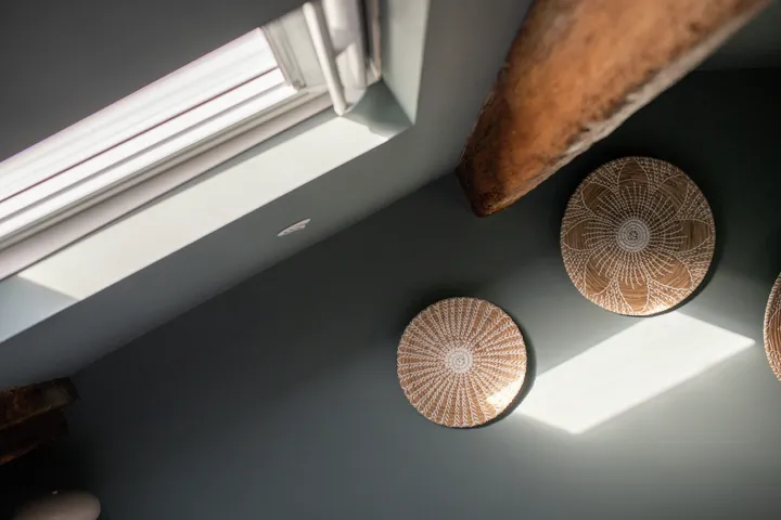 Strešno okno VELUX z dnevno svetlobo in barvno steno.| VELUX 