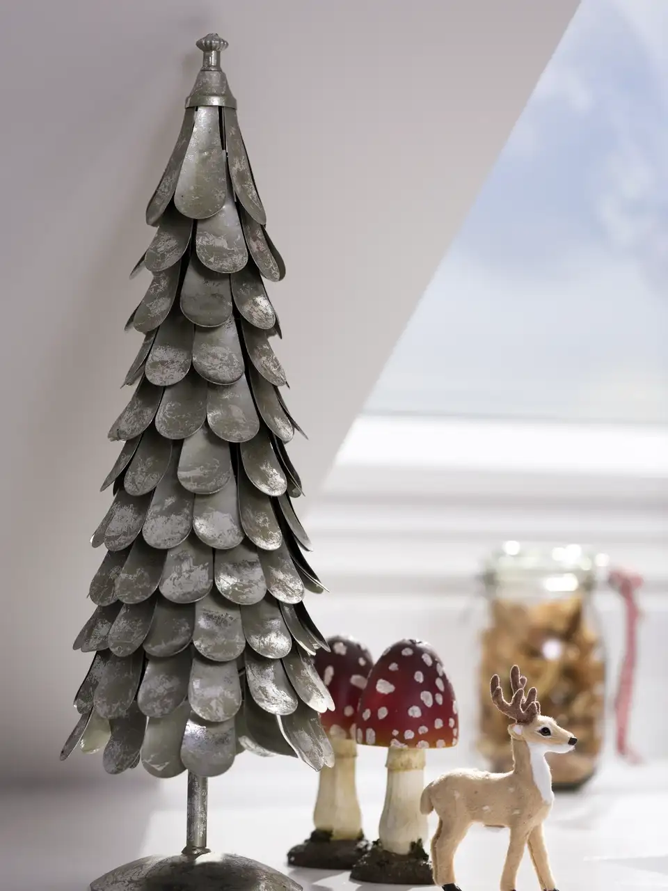 Albero in metallo e piccola renna in stile moderno vicino a una finestra per tetti VELUX.