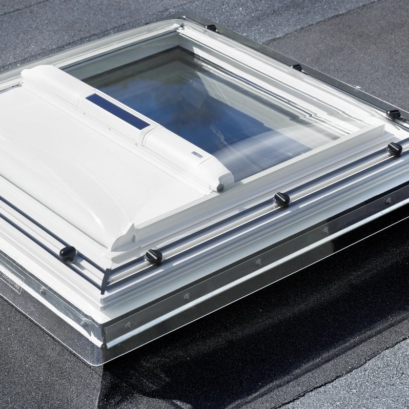 VELUX roof window on flat roof with roofing felt material.