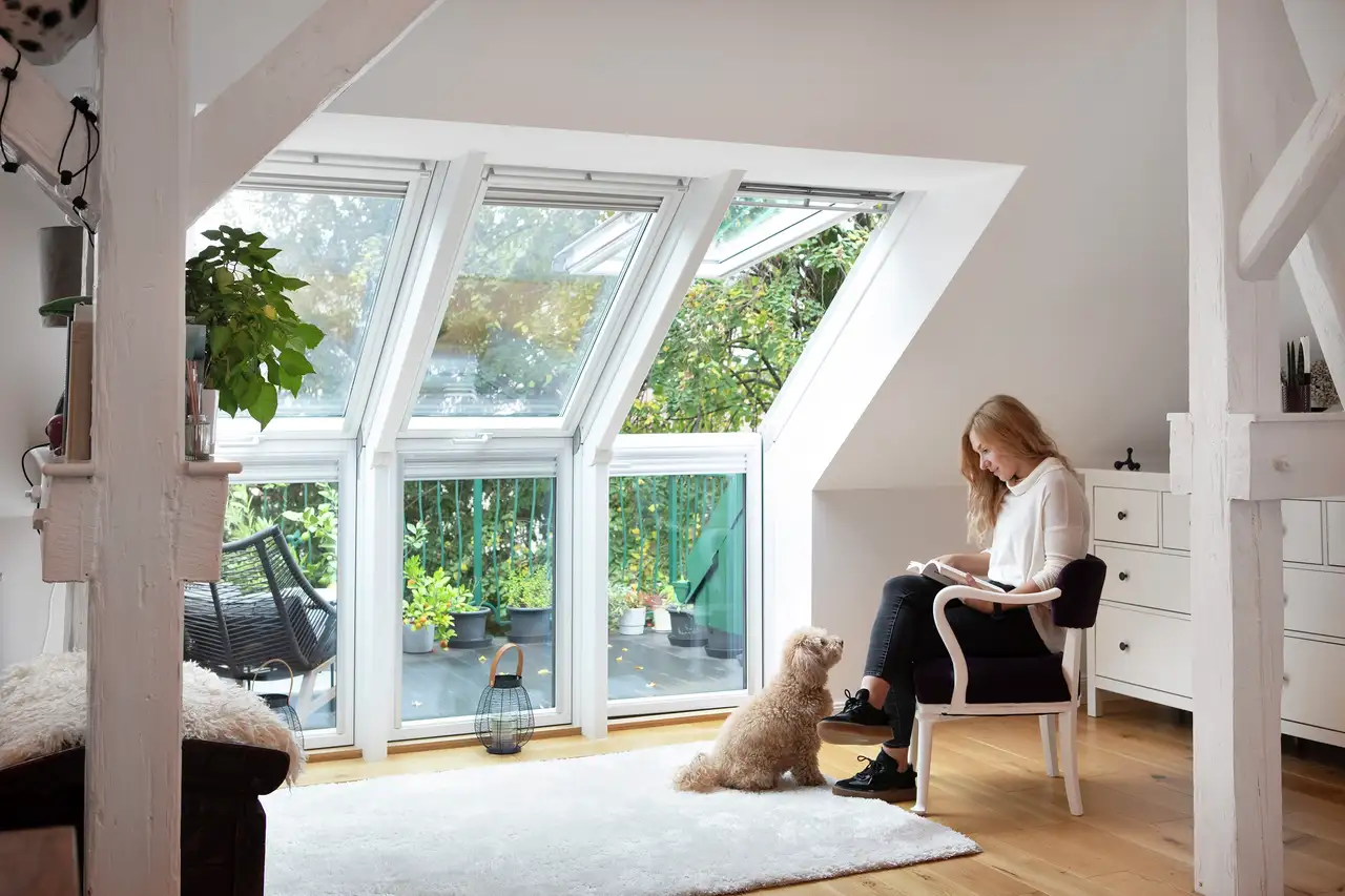Tre finestre per tetti VELUX affiancate illuminano l’angolo lettura di un loft