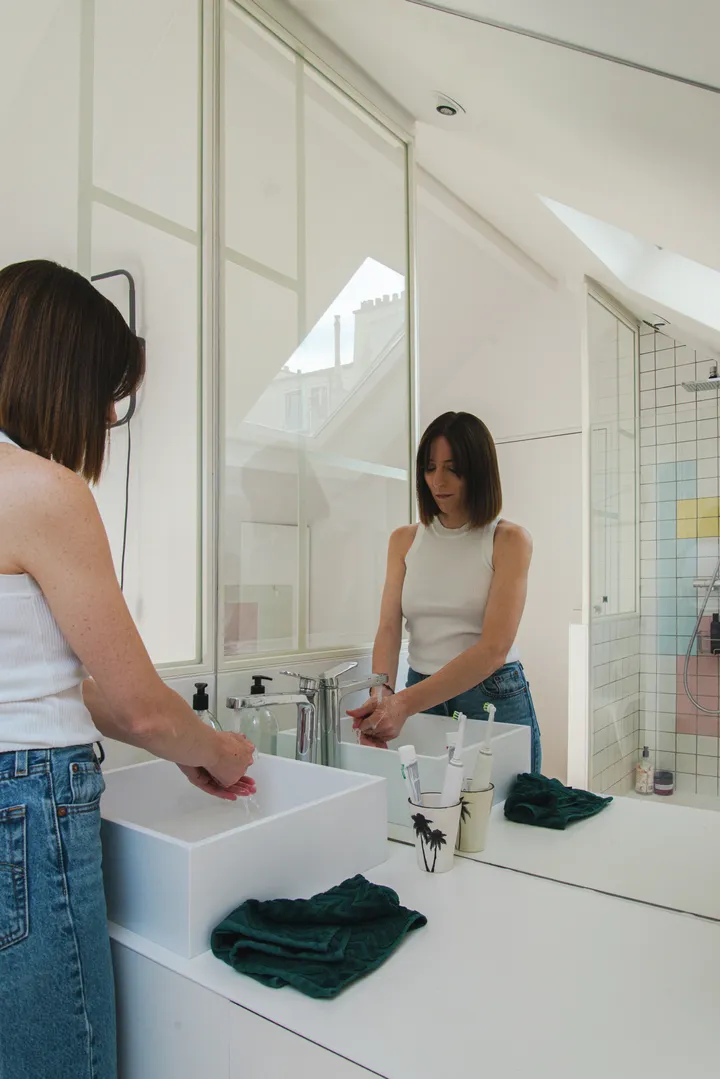 Frau wäscht sich die Hände neben ihrer Dusche unter der Dachschräge | VELUX Magazin