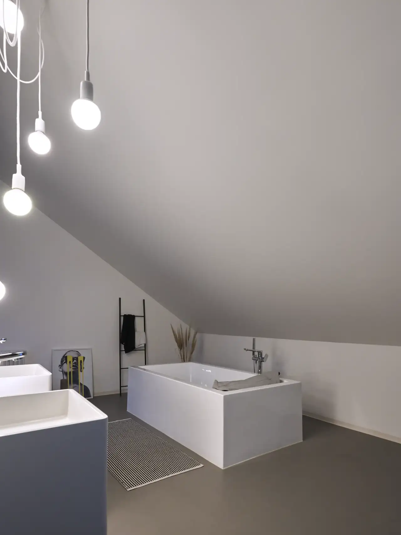 Vorher – dunkles Badezimmer unter Dachschräge mit freistehender Badewanne, Badematte und zwei Waschbecken | VELUX Magazin