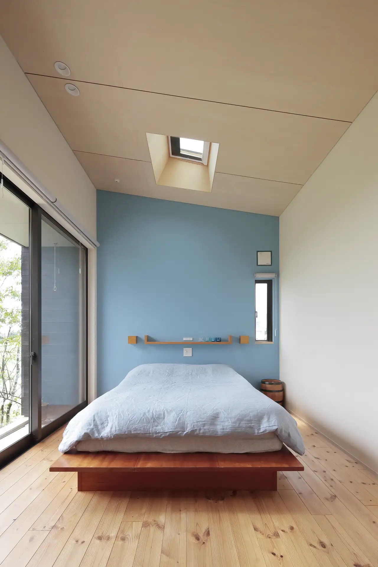 Schlafzimmer mit japanischem Bett, Holzfußboden und großer Fensterfront | VELUX Magazin