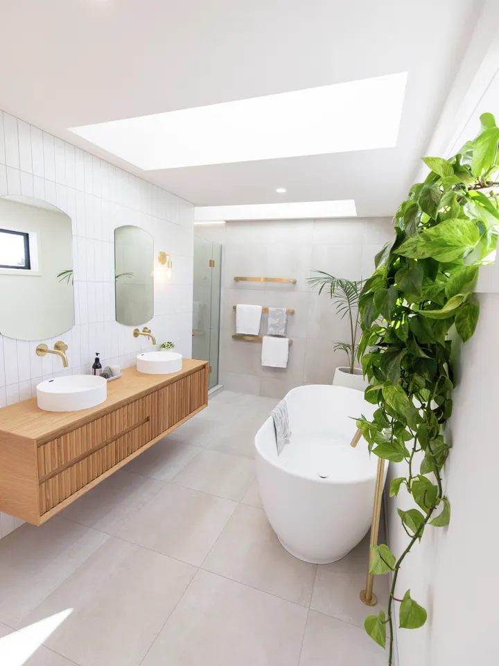 Modern bathroom with freestanding tub and VELUX flat roof windows filling the space with daylight.