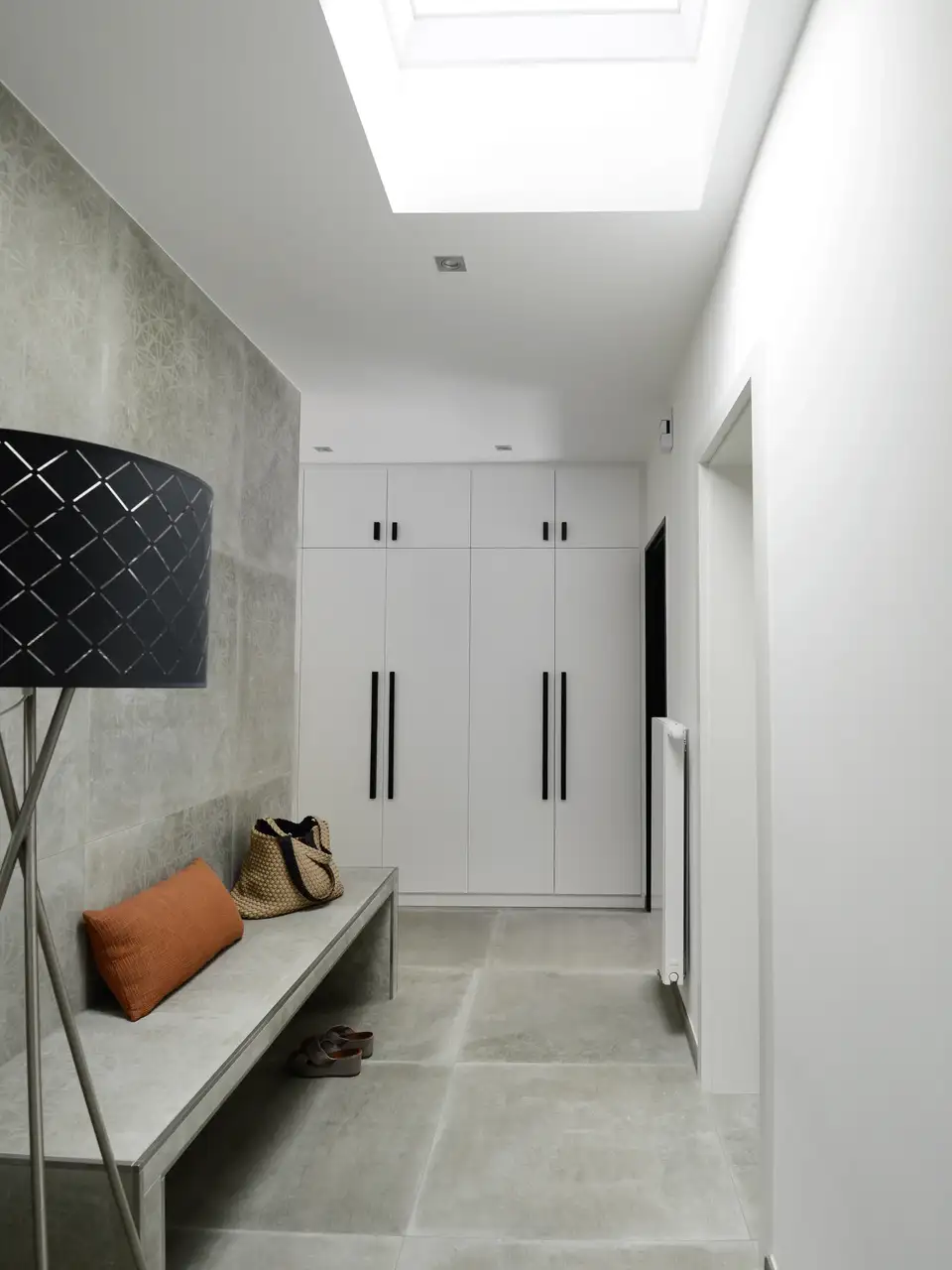 sol de couloir en carrelage gris de grande taille sous fenêtre de toit VELUX