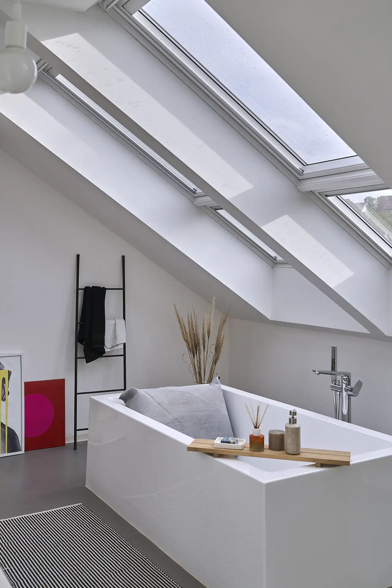 Freistehende Badewanne unter zwei Dachfenstern mit stilvollen Accessoires | VELUX Magazin