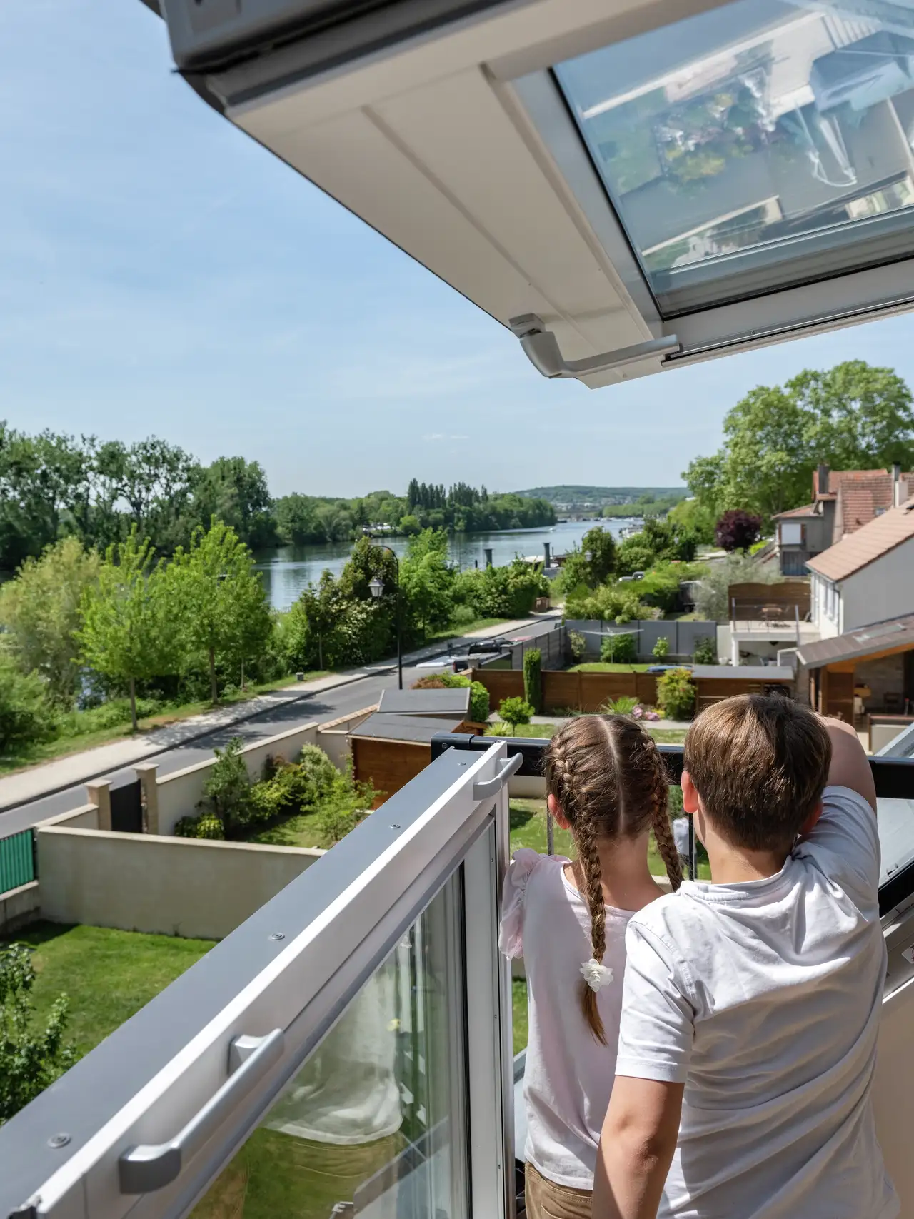 Enfants sur une fenêtre balcon avec vue, profitant de leurs vacances à la maison
