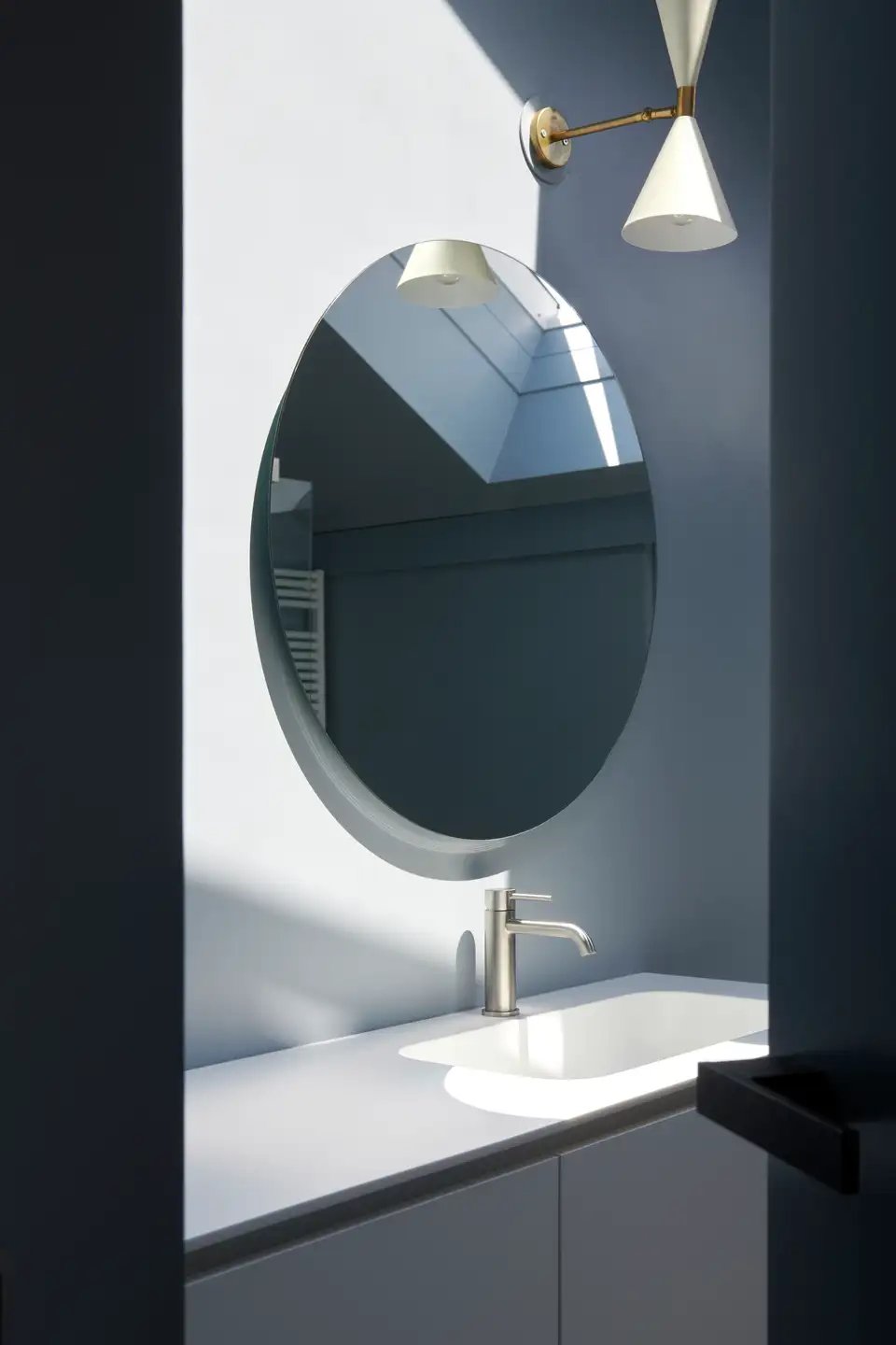 Kupatilo sa okruglim ogledalom, slavinom i VELUX krovnim prozorom.