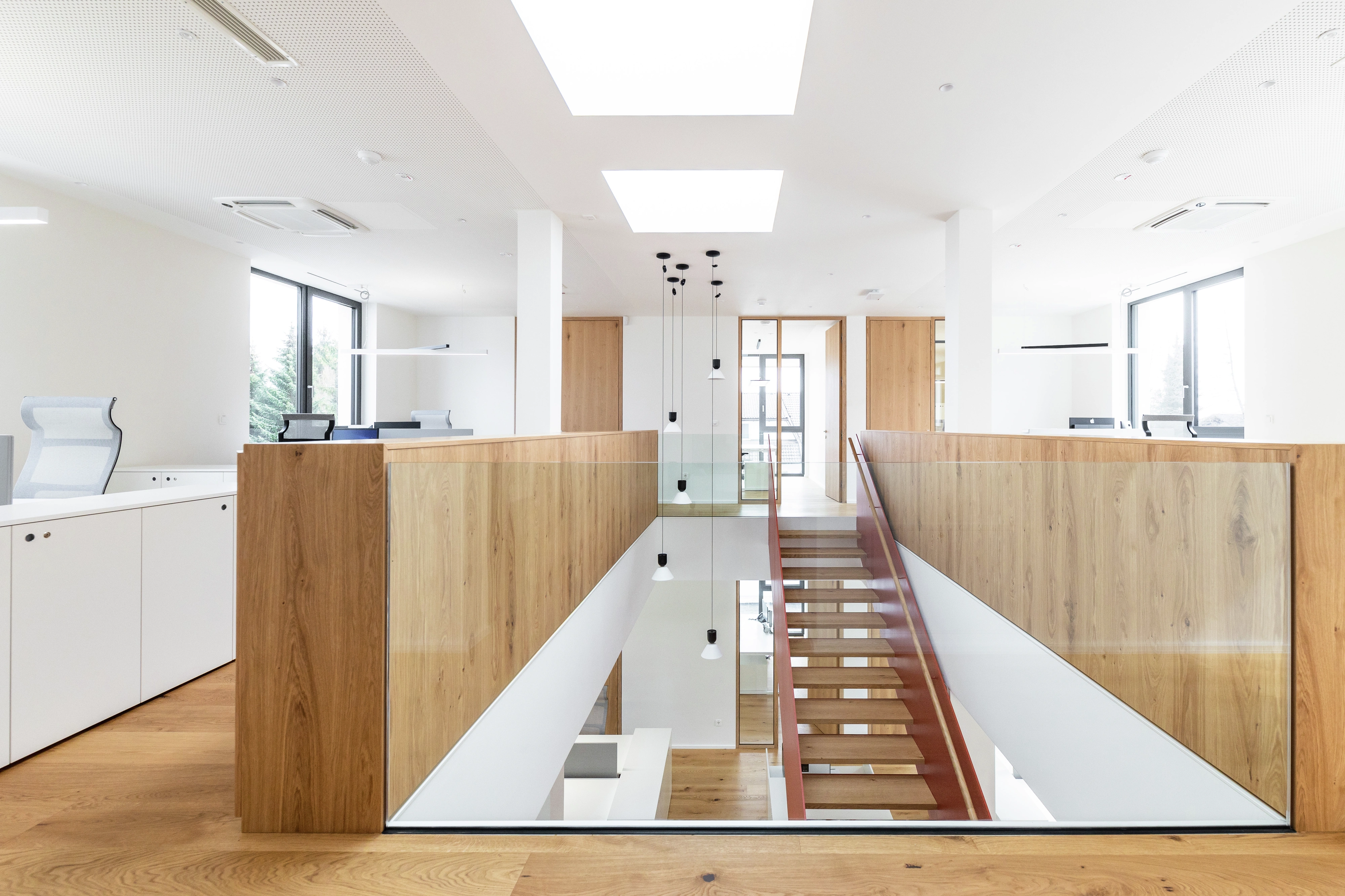 Moderní kancelář s centrálním schodištěm a střešním oknem VELUX
