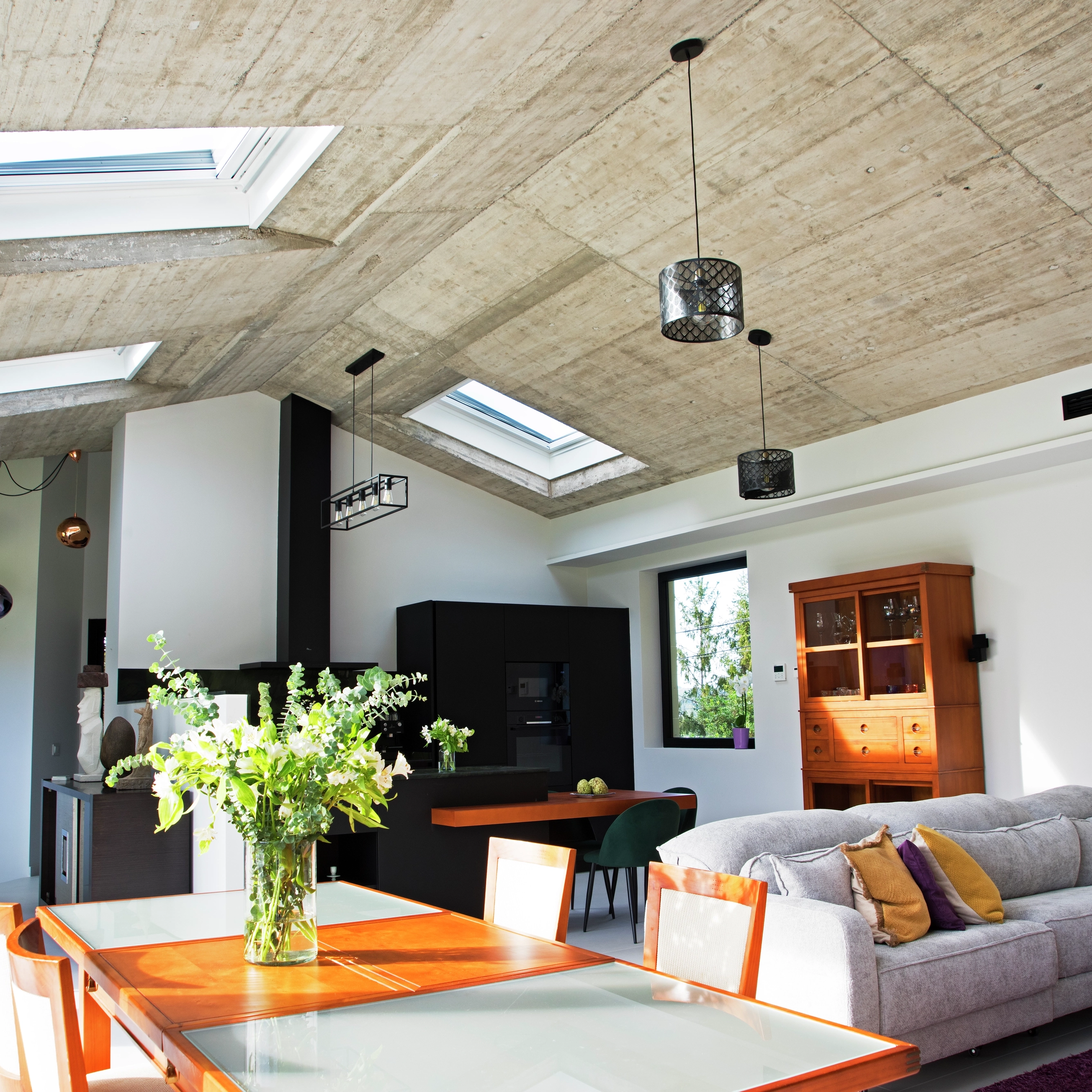 Cocina abierta al salón bajo techo inclinado con ventanas de tejado VELUX 