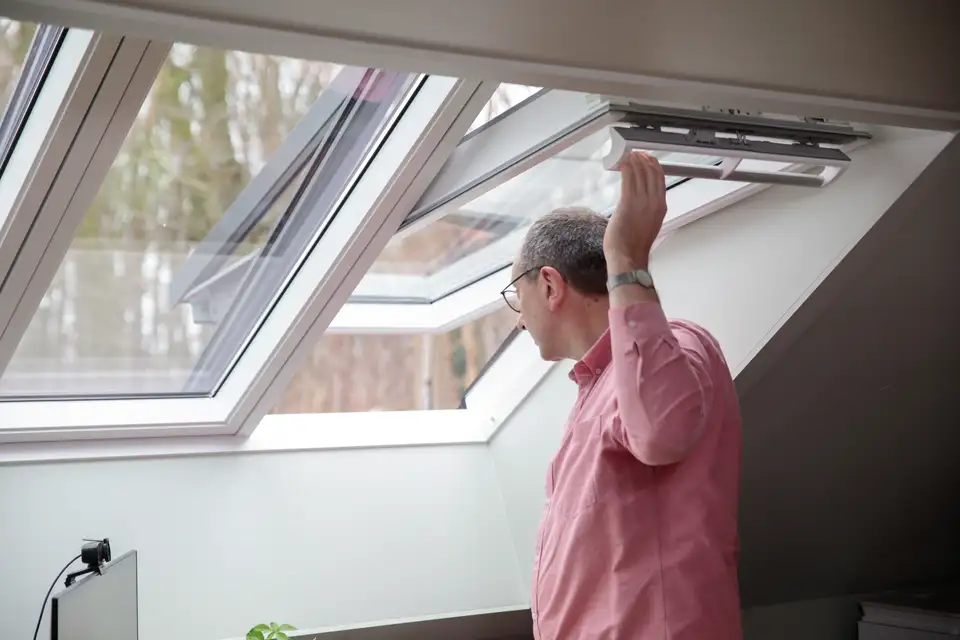 Man die een VELUX 3in1 dakvenster open doet 