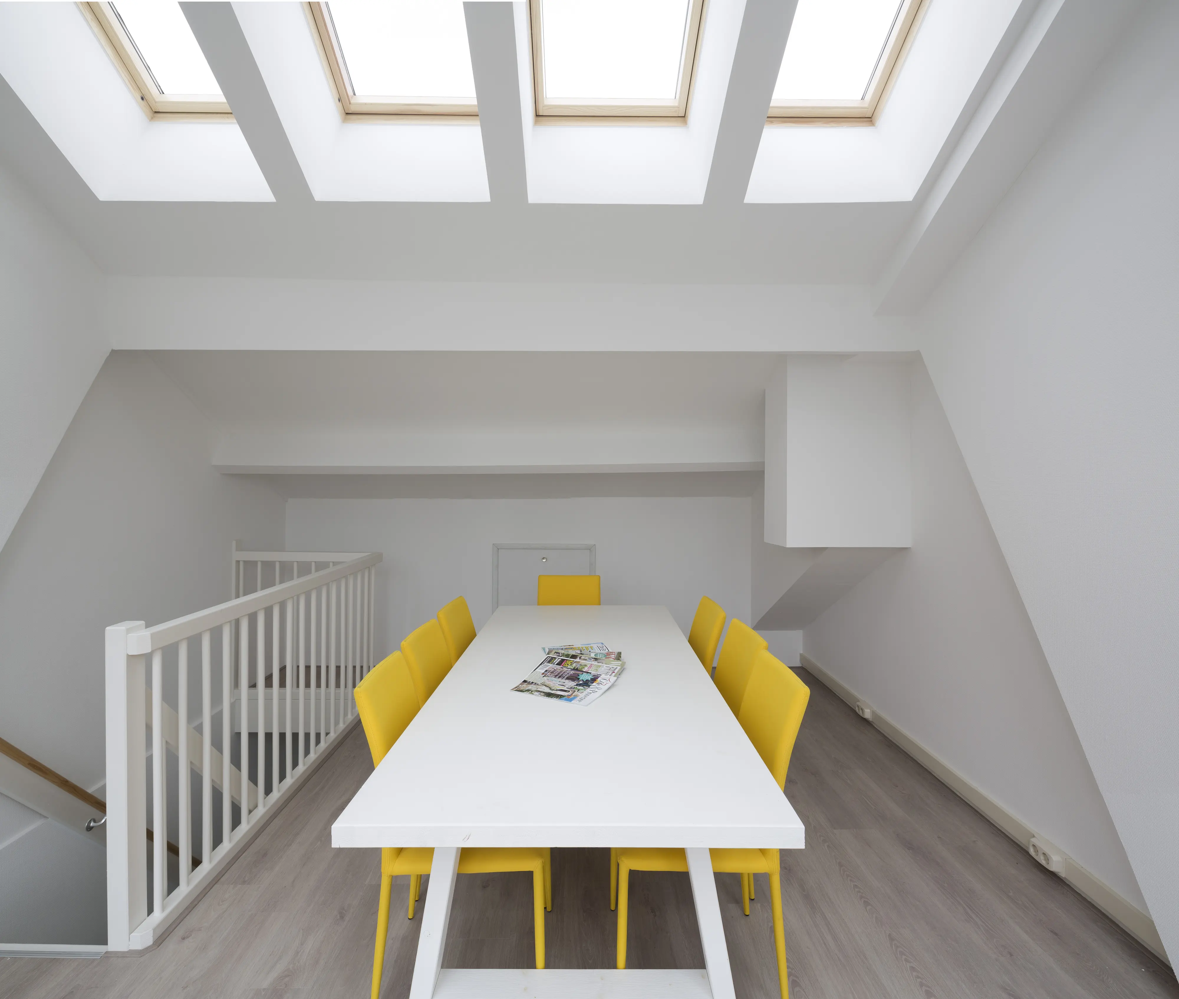 Attic meeting room with sloped ceiling and VELUX roof windows, bright and spacious.