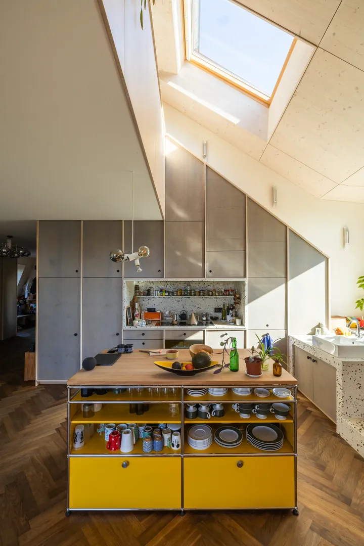 Moderna virtuve ar koši dzeltenu salu un plašu VELUX jumta logu, kas uzlabo dabiskās gaismas iekļūšanu | VELUX.