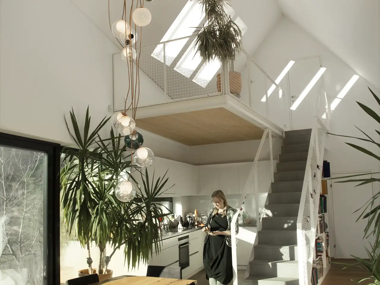 Donna in cucina luminosa con lampada da soffitto creativa | Rivista VELUX