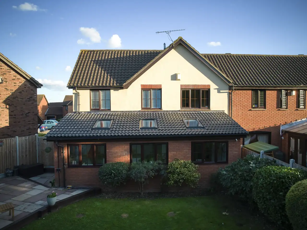 Residential house with extension and VELUX roof windows, tiled roof.