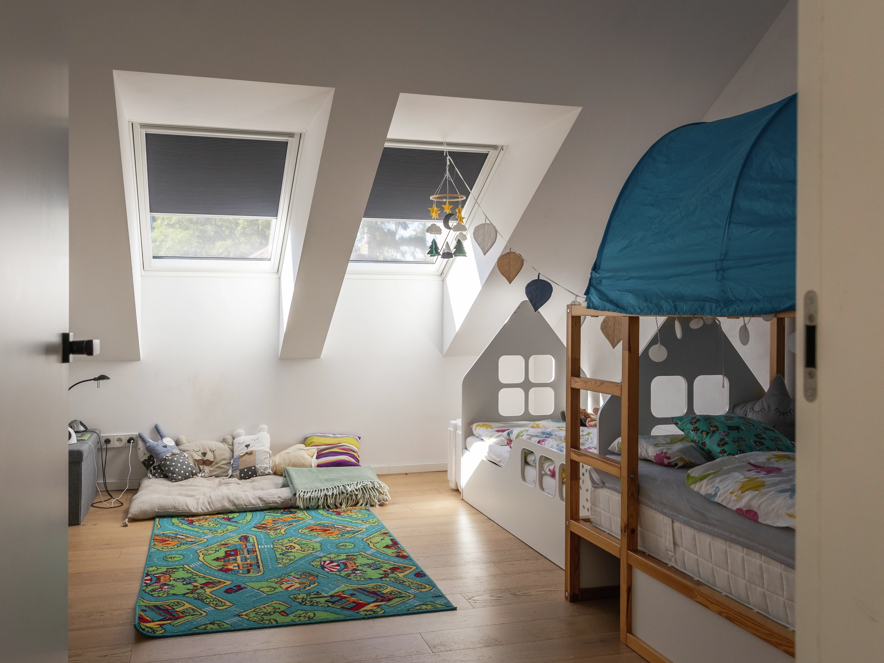 Attic kids room with sloped ceiling and VELUX roof windows.
