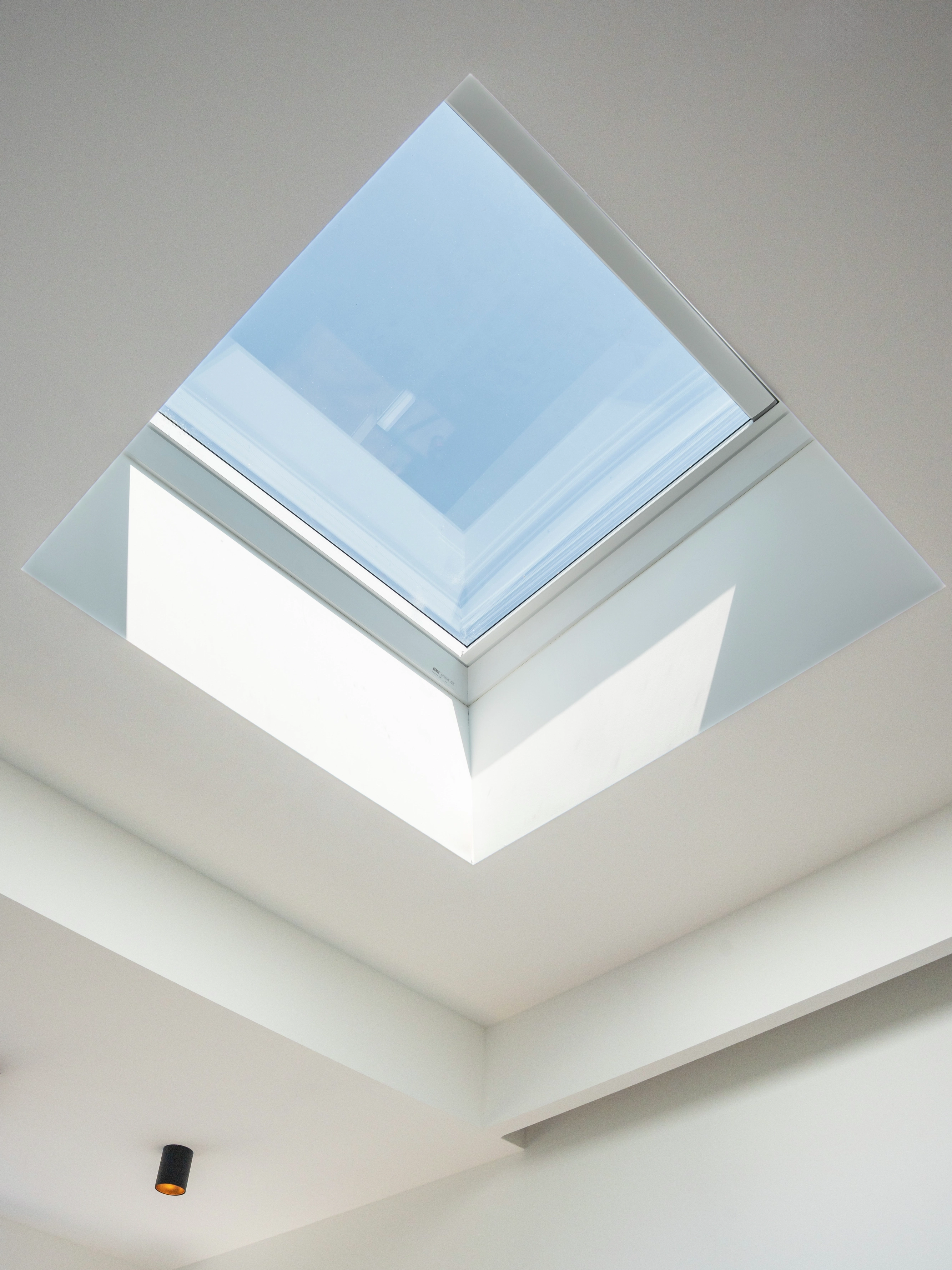 VELUX flat roof window in a bright room with flat ceiling.