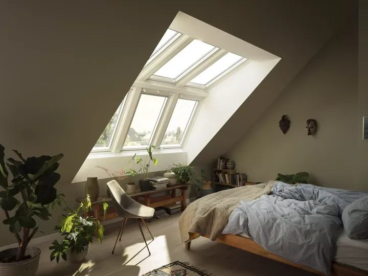 Gemütliches Schlafzimmer mit VELUX Dachflächenfenster, Pflanzen und natürlichem Licht.