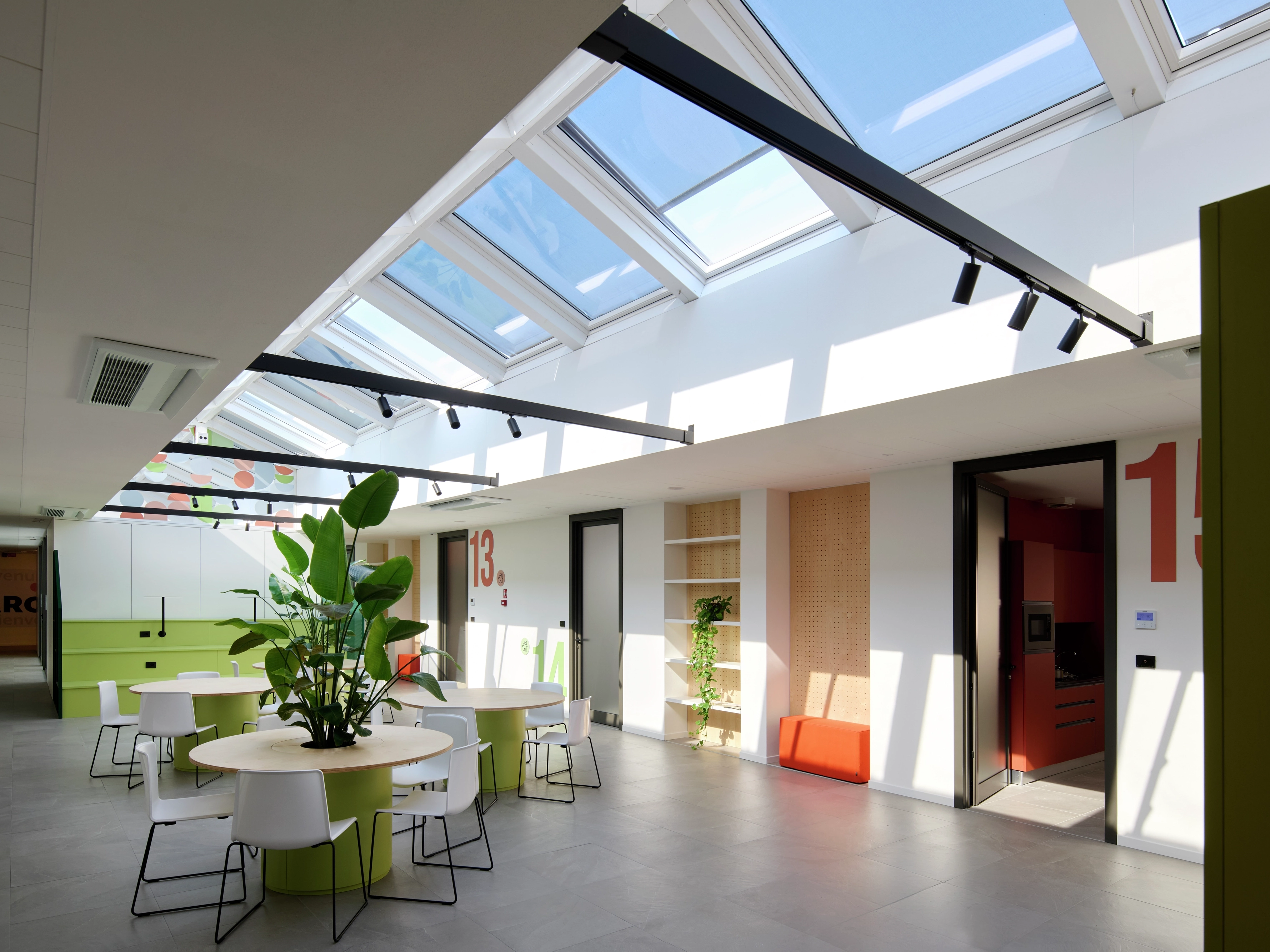 Spazio comune all’interno di un edificio illuminato da finestre per tetti VELUX affiancate.