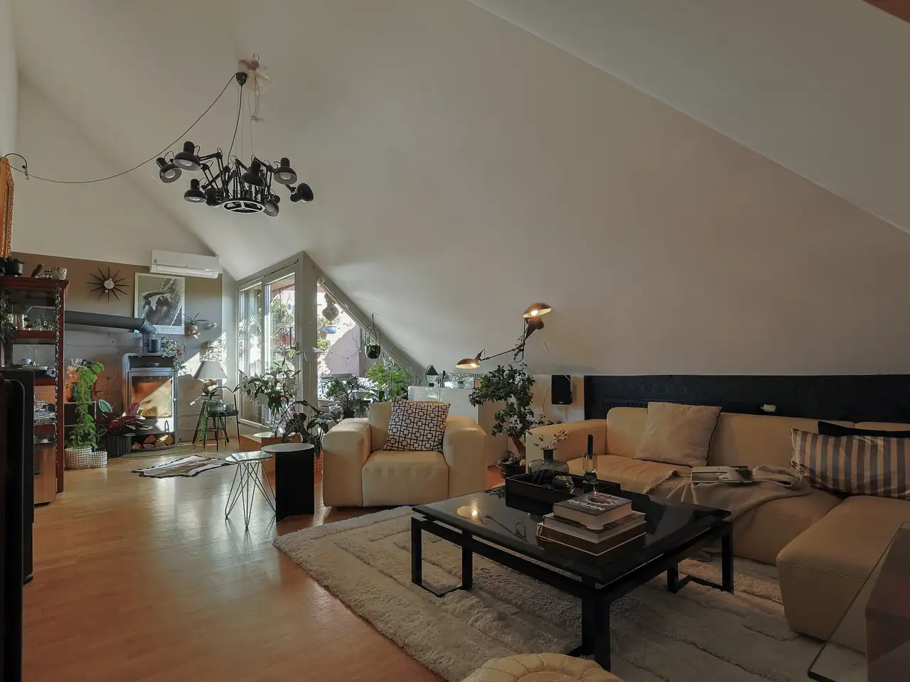 Divano angolare beige in un soggiorno scuro con un balcone come piccola fonte di luce naturale | Rivista VELUX