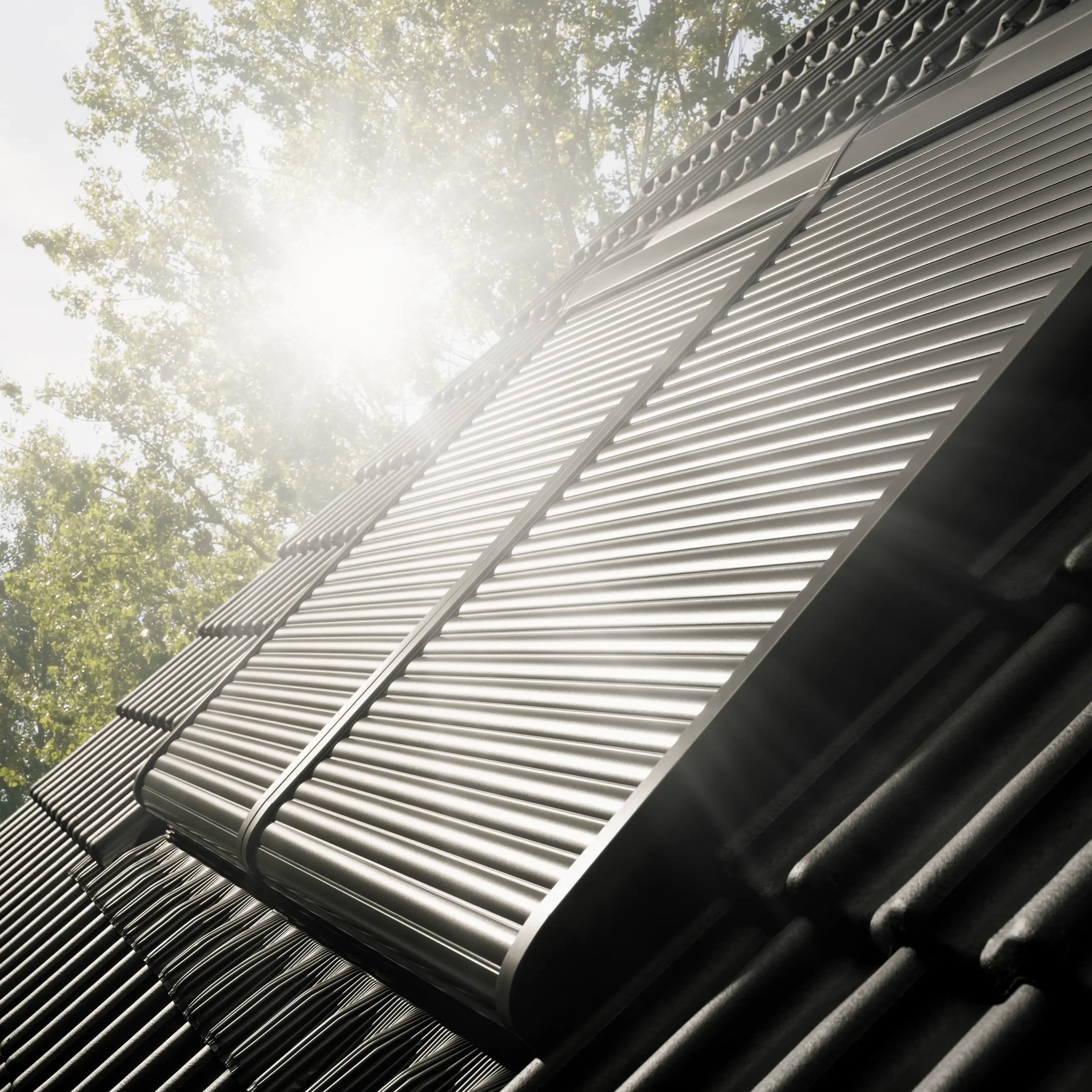 Roof with integrated solar panels reflecting sunlight, surrounded by trees.