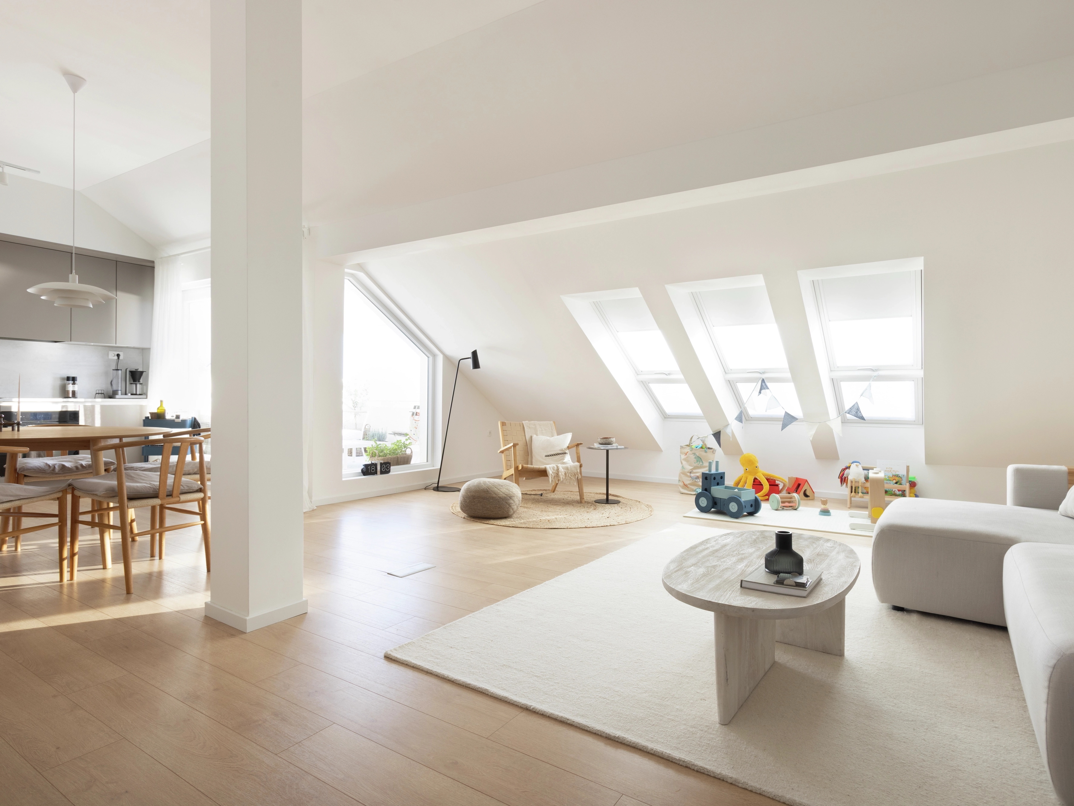 Attic room with VELUX roof windows, dining area, and kids' play corner.