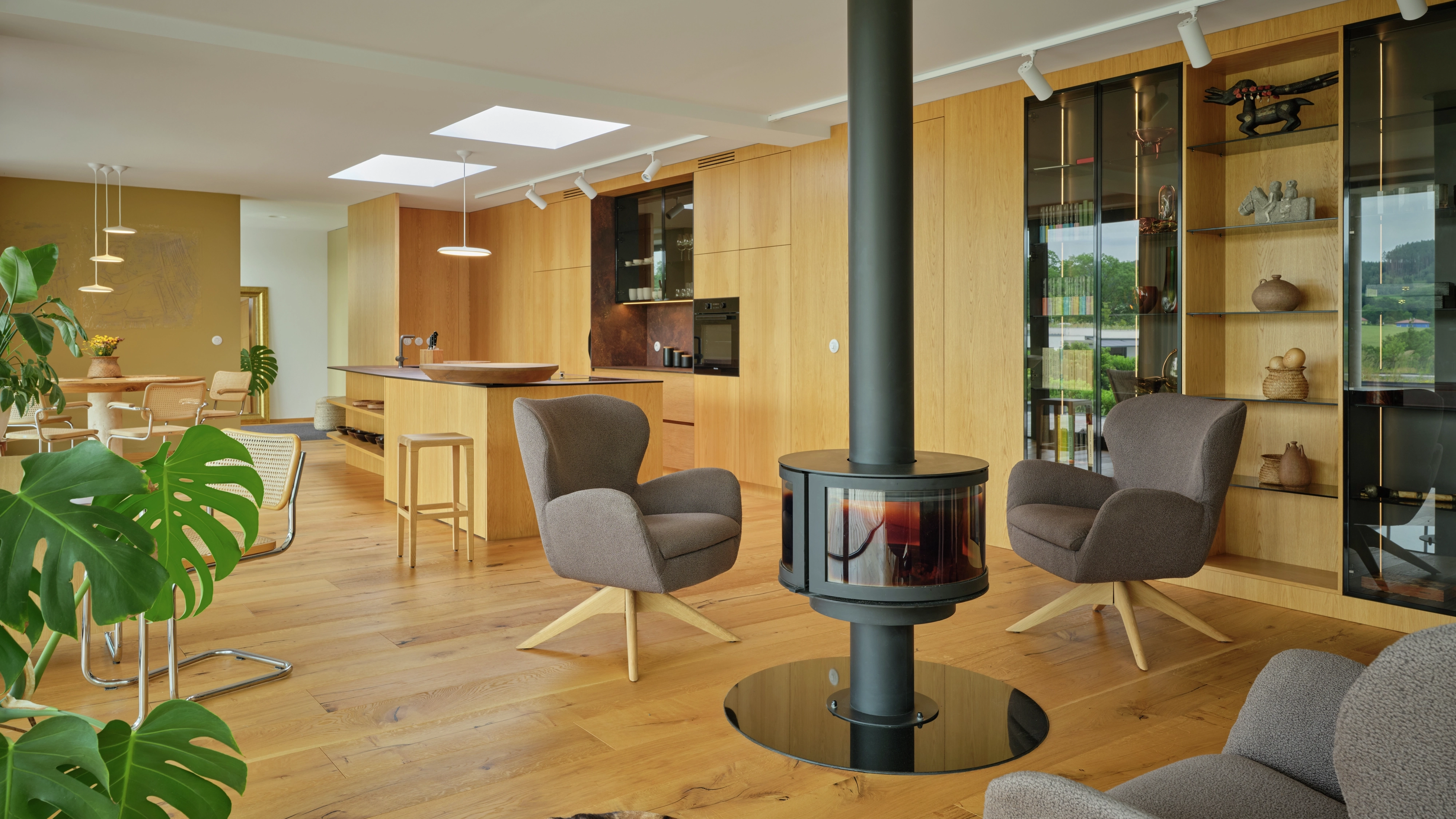 Open-plan living kitchen with VELUX flat roof windows and central fireplace.