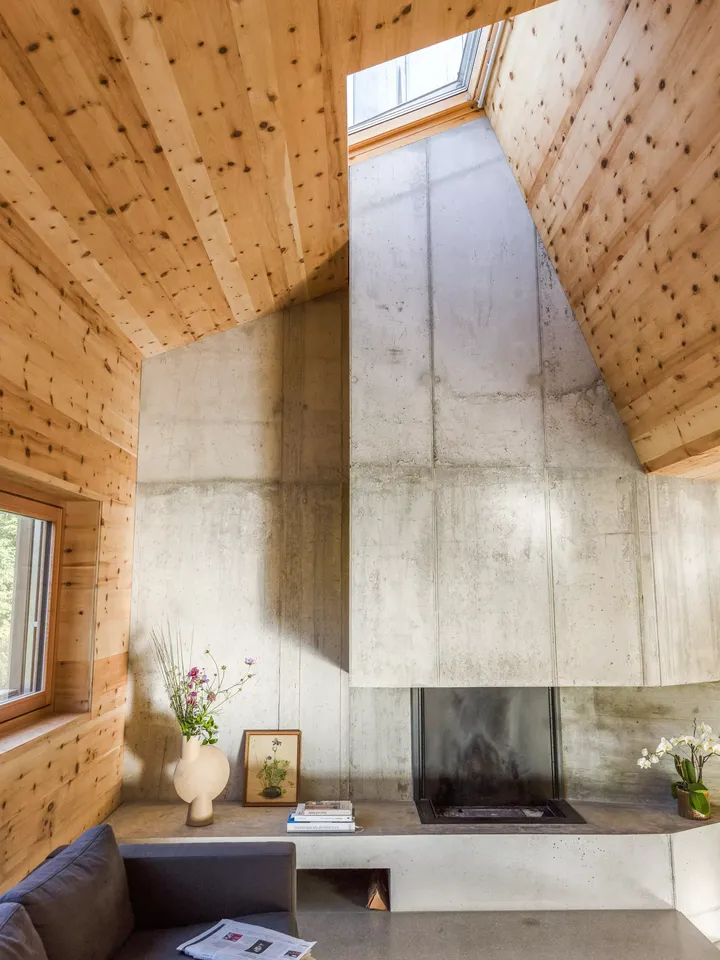 Un espace intérieur confortable et bien éclairé par la lumière naturelle filtrant à travers un puits de lumière Velux, mettant en valeur les murs en bois et créant une atmosphère accueillante.