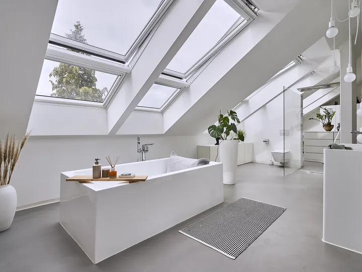 Weißes Badezimmer mit freistehender Badewanne unter Dachfensterkombination | VELUX Magazin