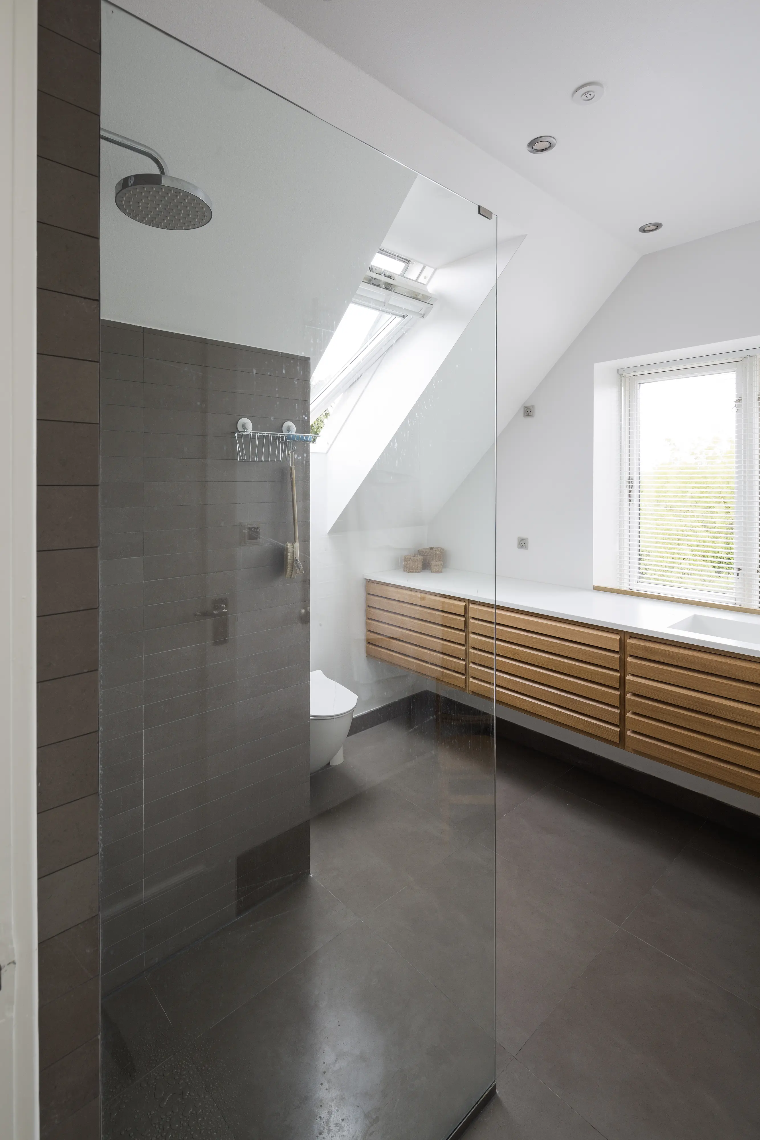 Baie modernă cu tavan înclinat și fereastră de mansardă VELUX.