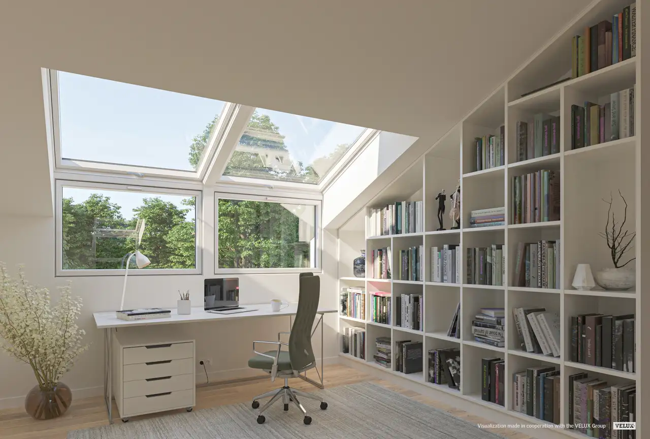 Bureau aménagé sous combles avec de grandes fenêtres de toit VELUX et bibliothèque murale intégrée.