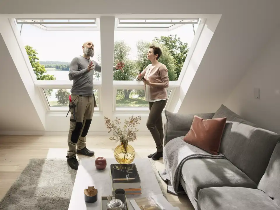 Handwerker in einem Beratungsgespräch mit einer Bauherrin zu VELUX Dachfenstern.