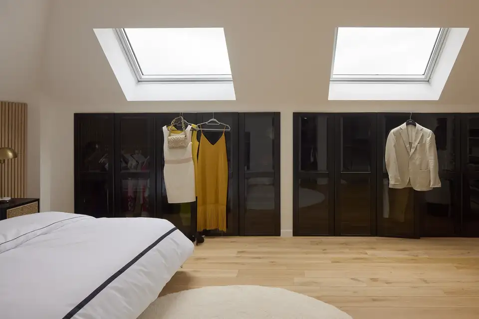 Armadio ad ante scure in mansarda illuminato da finestre per tetti VELUX.