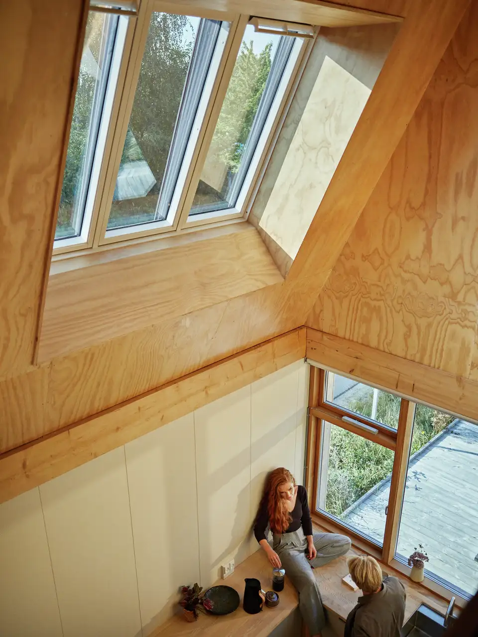 Femme assise dans une cuisine avec fenêtre VELUX 3in1.