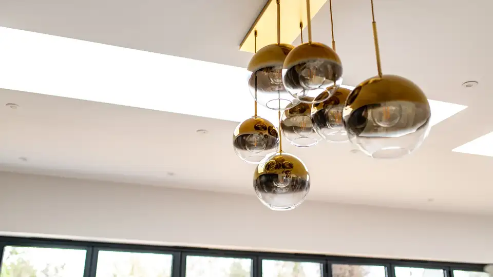 Suspensions sphériques en verre métallisé dans un intérieur avec fenêtres verticales et fenêtres pour toit plat VELUX .