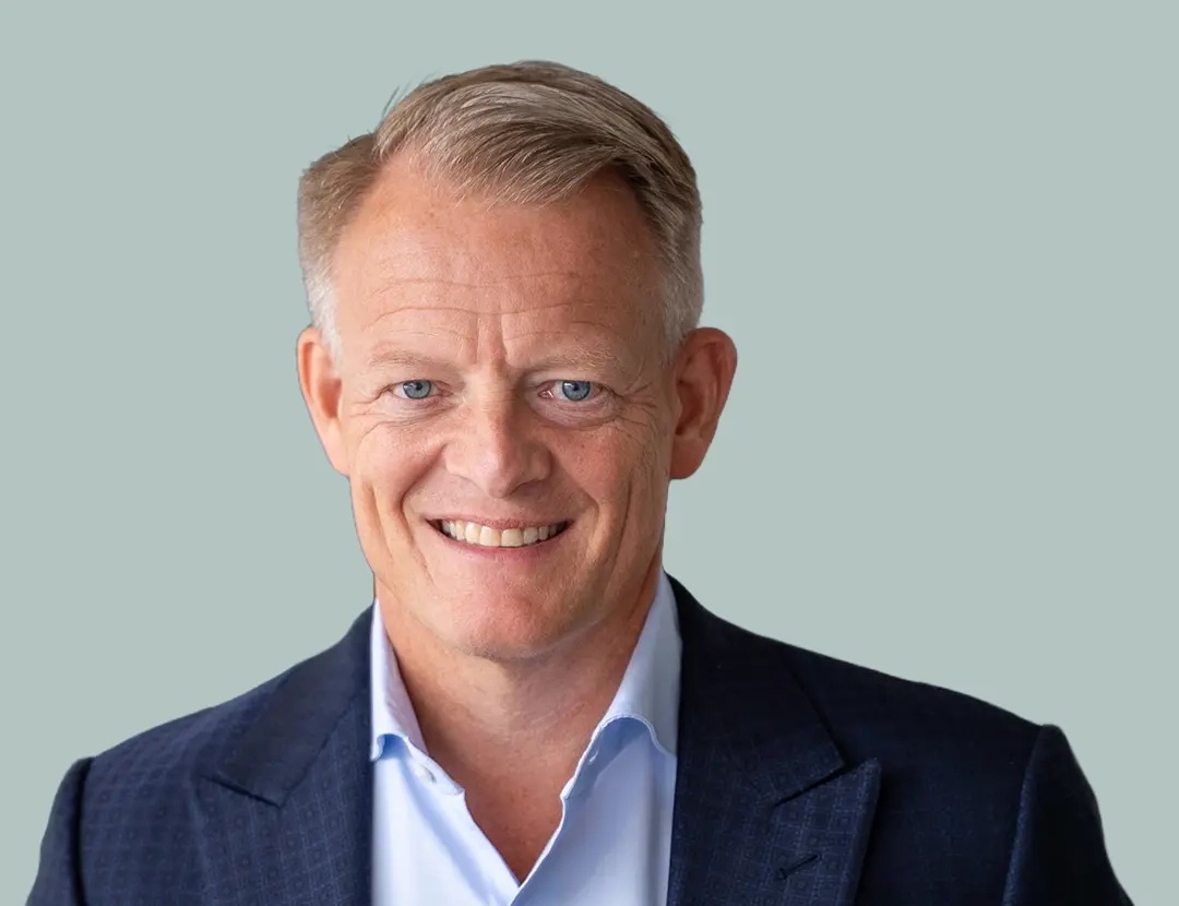 Person in a blue suit jacket and light blue shirt, professional attire.