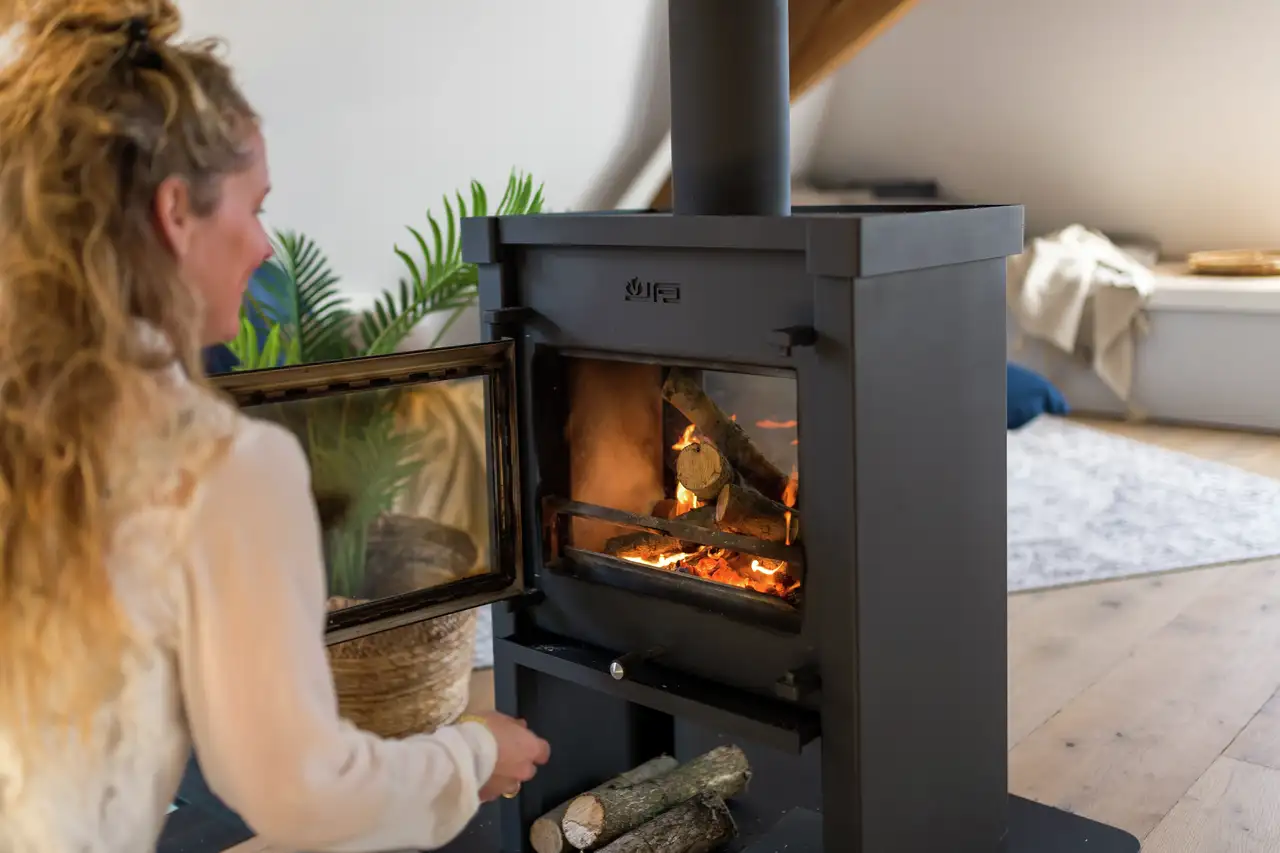 Frau öffnet Tür von freistehendem Kamin | VELUX Magazin