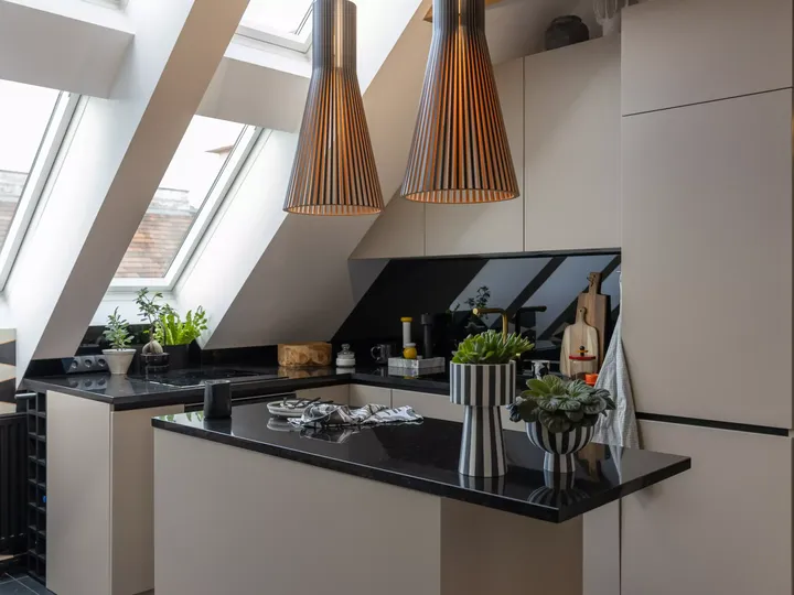 Moderne Dachbodenküche mit VELUX Dachflächenfenster und hölzernen Akzenten.