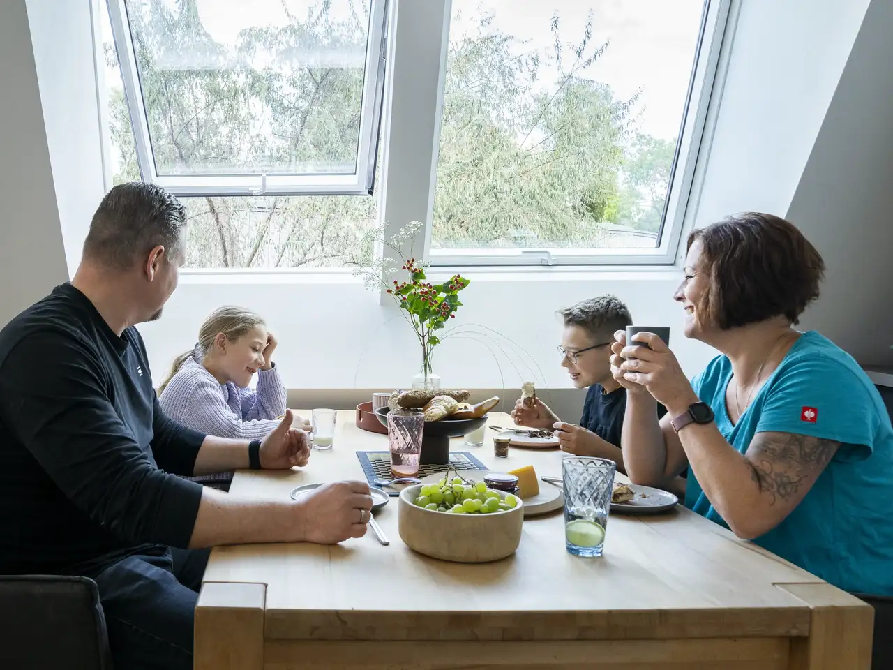 Famille déjeunant autour d’une table près de fenêtres de toit VELUX