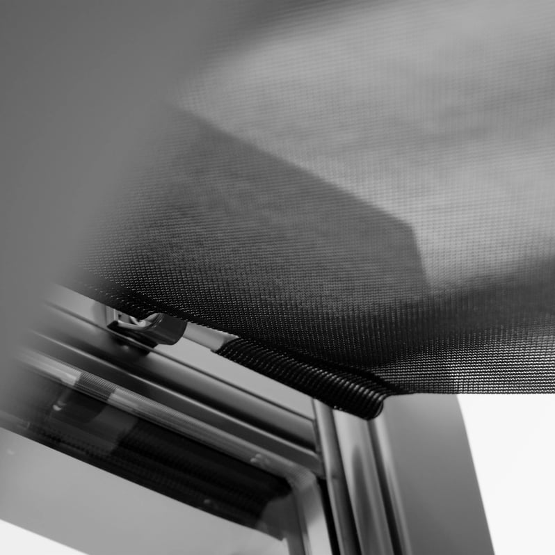 Close-up of VELUX roof window with mesh screen, showcasing design details.