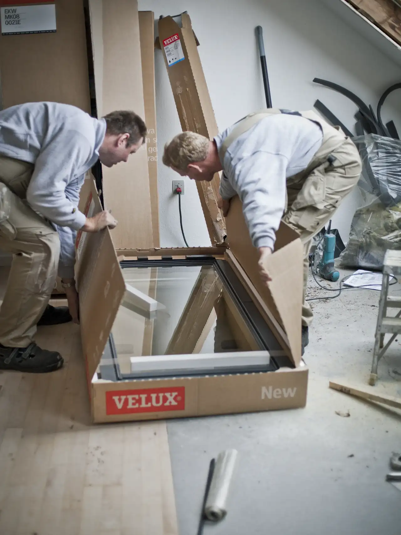 Due installatori VELUX aprono la confezione di una nuova finestra per tetti.