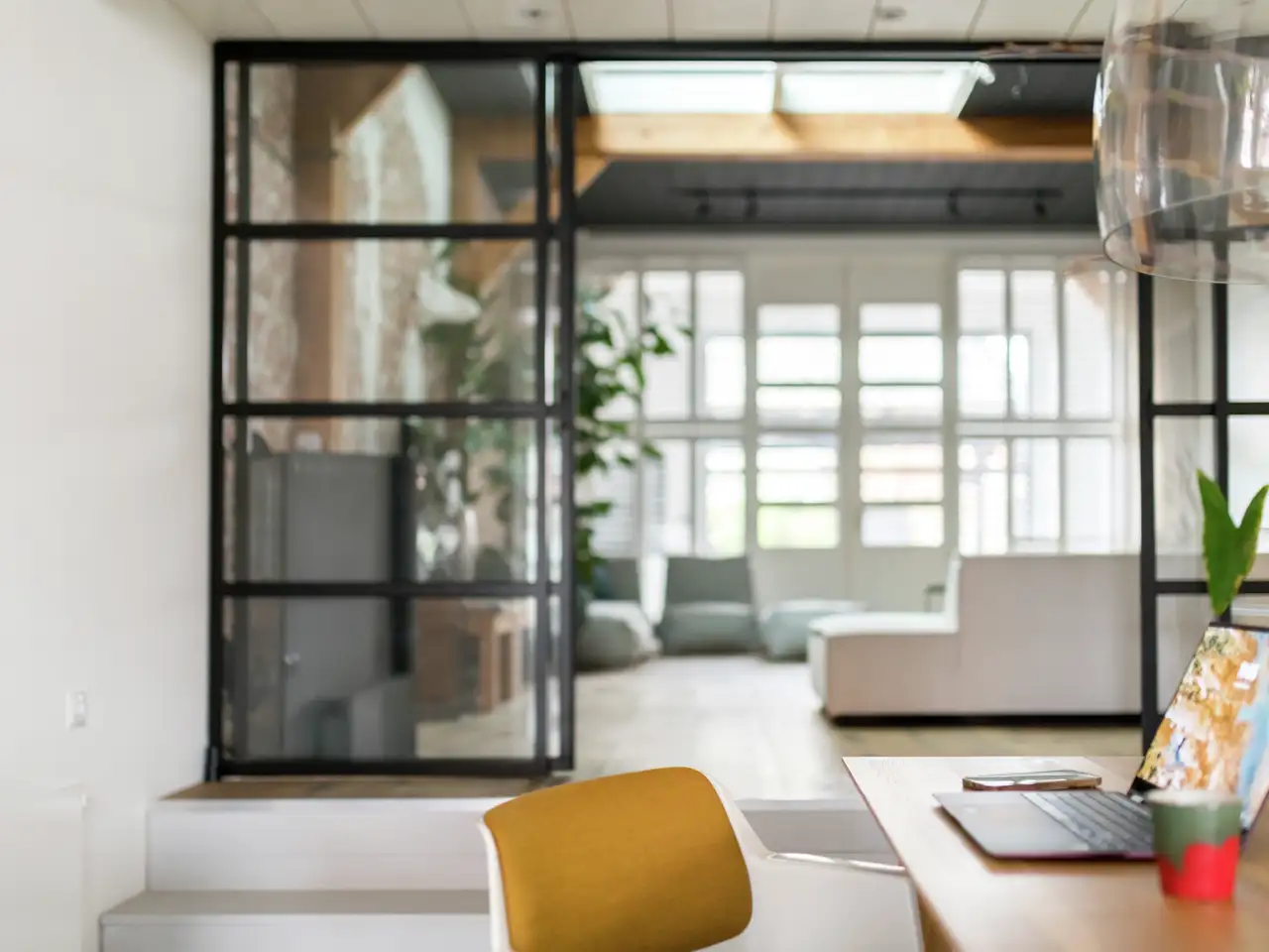 Essbereich mit angrenzendem Wohnzimmer, getrennt durch verglasten Raumteiler | VELUX Magazin