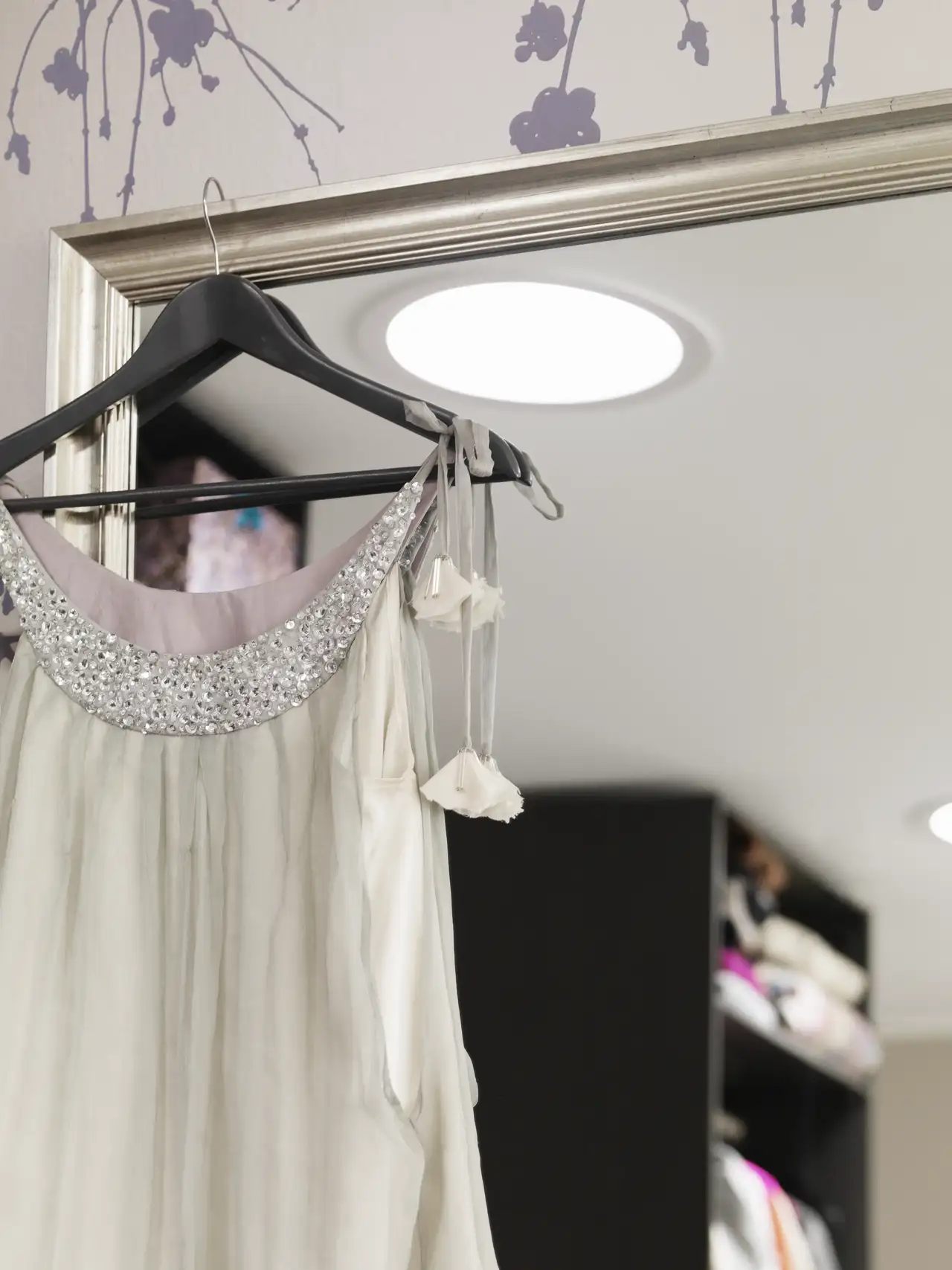 Fragment garderoby ze świetlikiem tunelowym odbijającym się w lustrze.